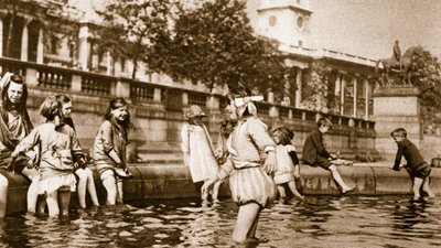 West End children cooling themselves in a fountain at Trafalgar Square during a heat wave by English Photographer